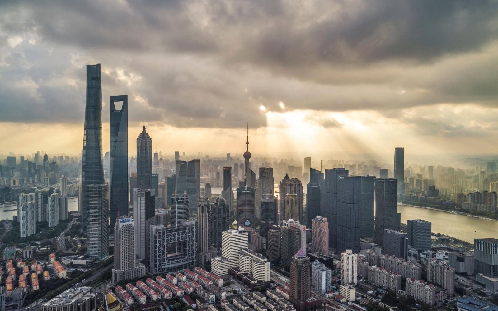 Vista aérea de uma metrópole chinesa com arranha-céus sob céu nublado
