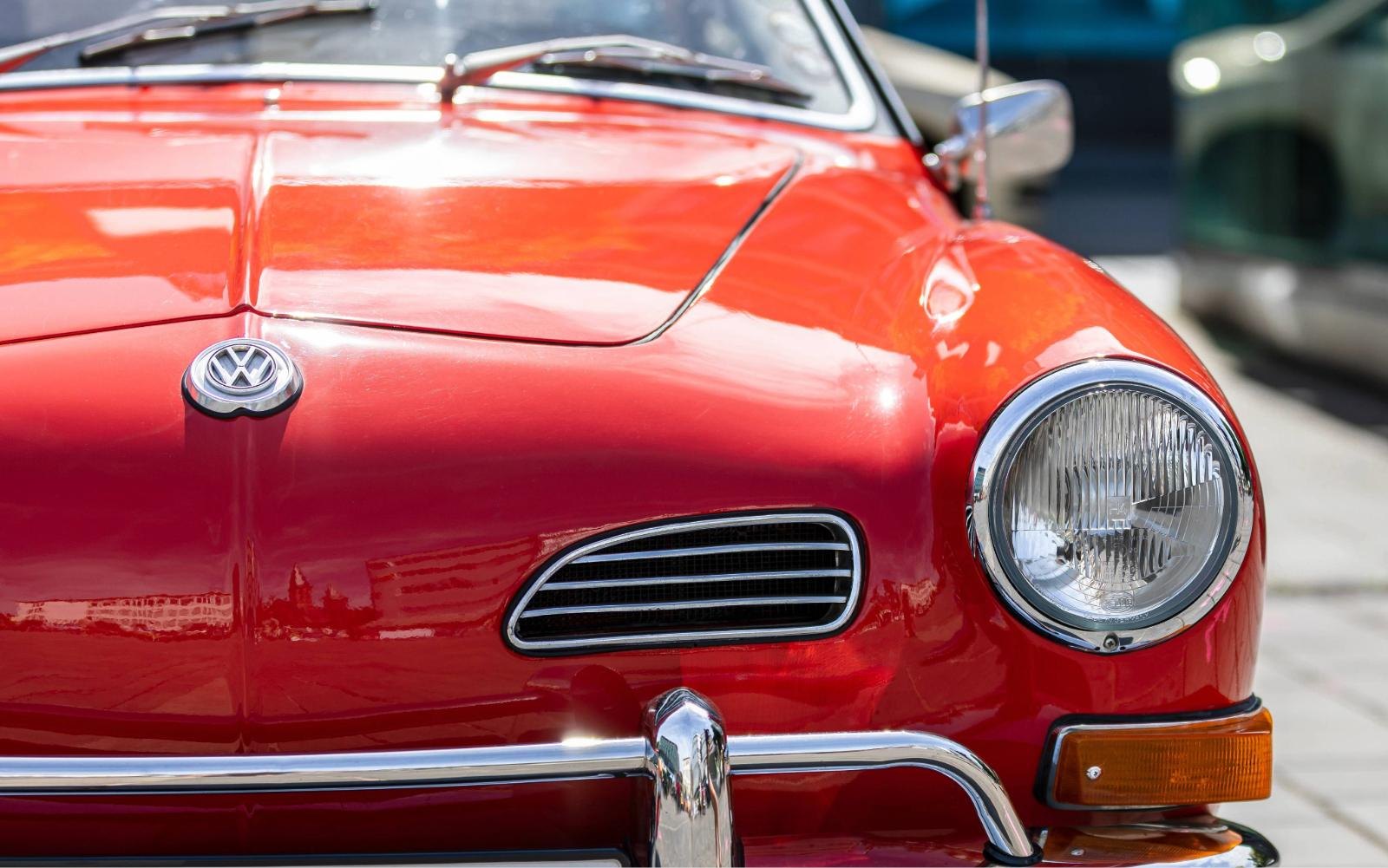 Frente de um carro vermelho com o emblema da Volkswagen