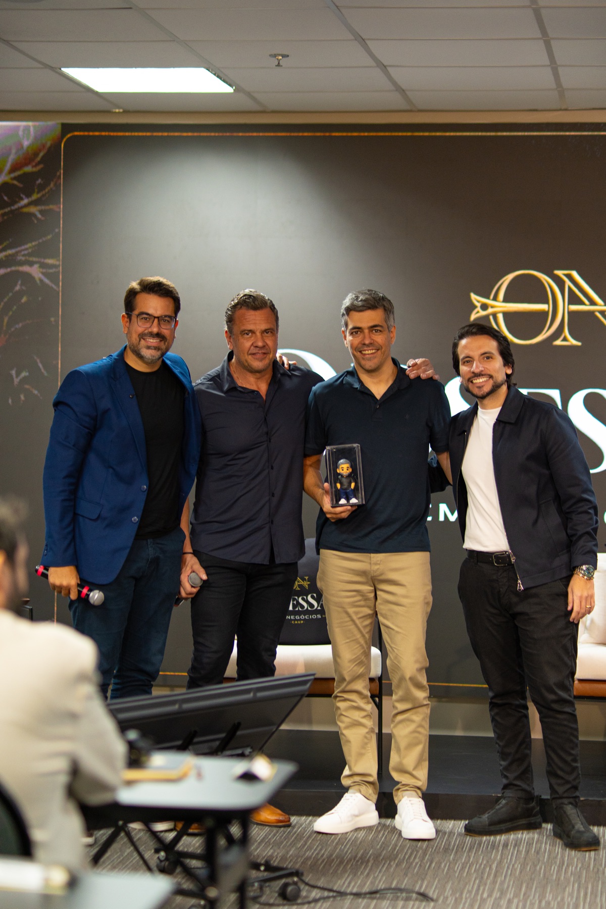 Mentores da Capital Upgrade com um membro no palco do Obsessão em Negócios